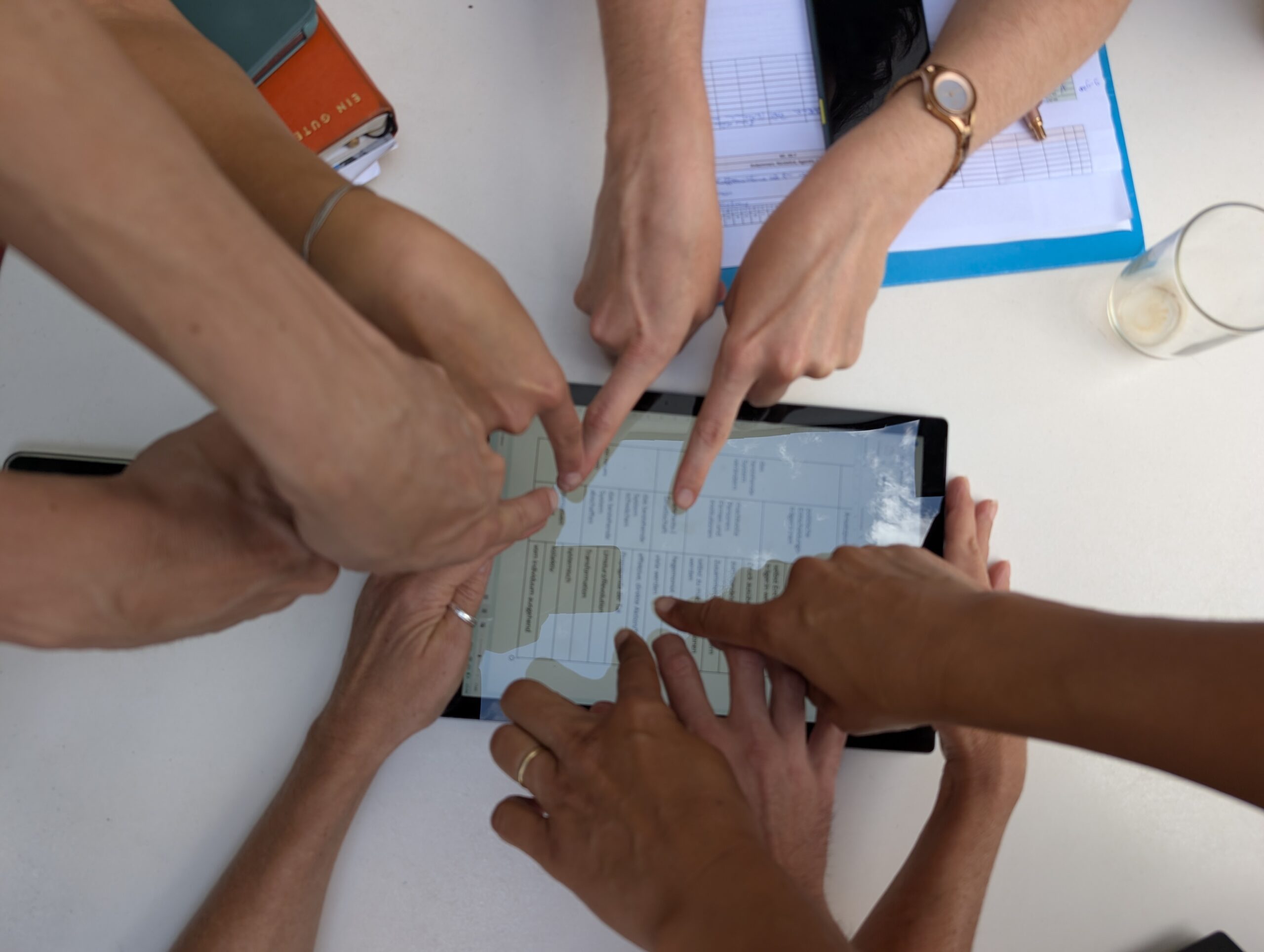 Teachers For Future zeigen auf ein Tablet - Teamwork For Future