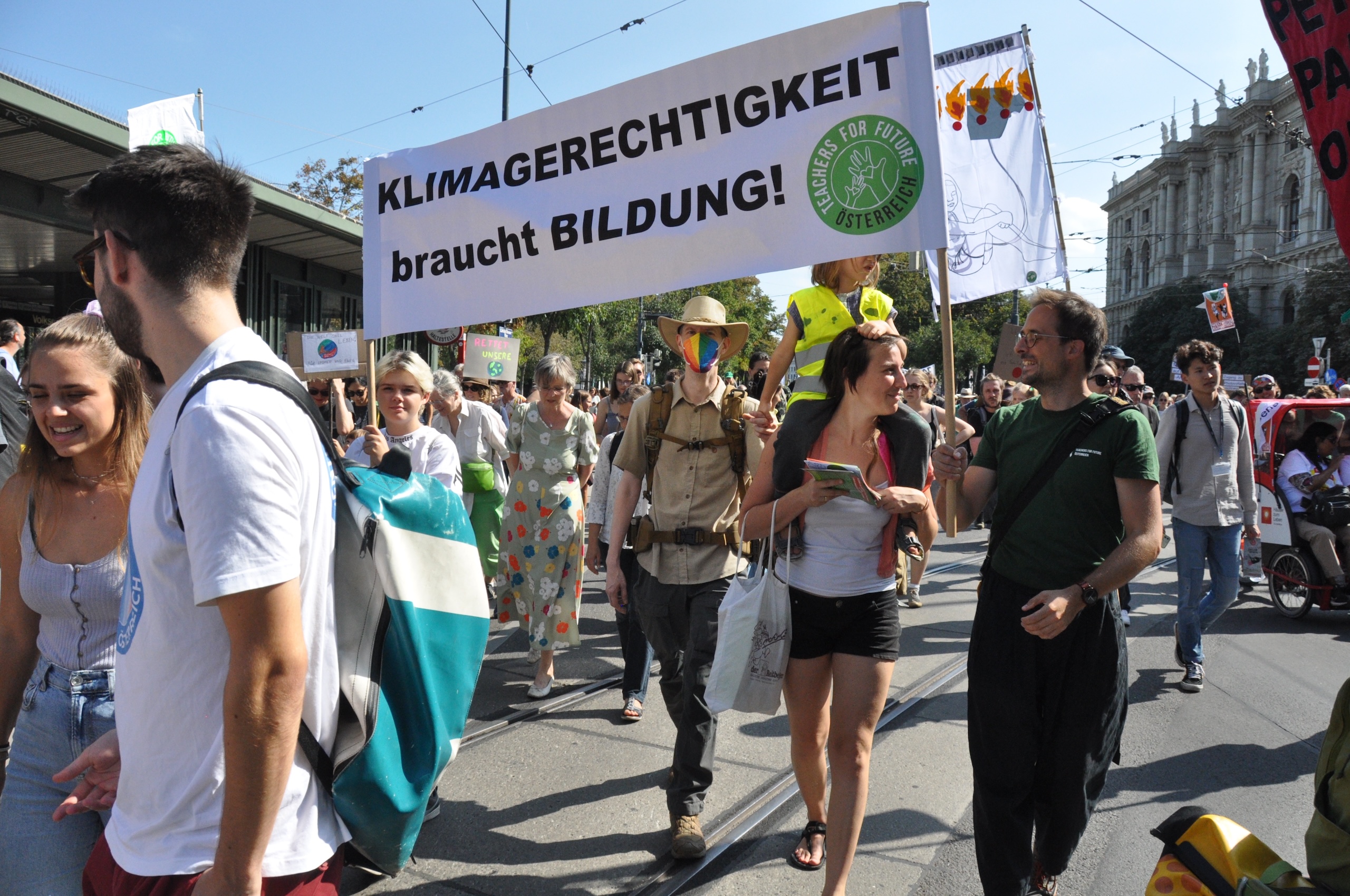 Teachers for Future beim Demonstrieren. Aktivisti halten ein Transparent mit der Aufschrift "Klimagerechtigkeit braucht Bildung" hoch